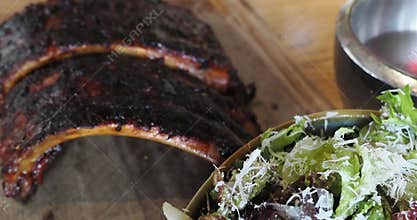 Camera pans to racks of freshly barbeque pork ribs