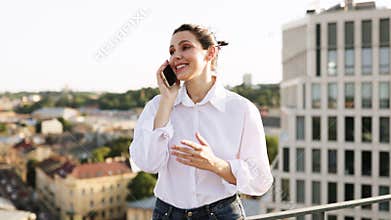 Smiling woman on phone call outside modern office building