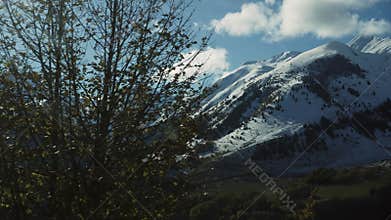 Snowcapped mountain peaks under a clear blue sky offer breathtaking vistas of majestic highlands