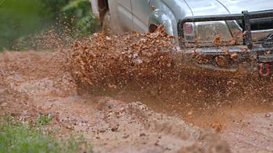 Cars running on off-road roads and splashing mud on natural paths. Off-road travel on muddy road. Offroad travel and driving