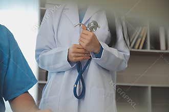 Young doctor is using a stethoscope listen to the heartbeat of the patient. Shot of a female doctor giving a male patient a check