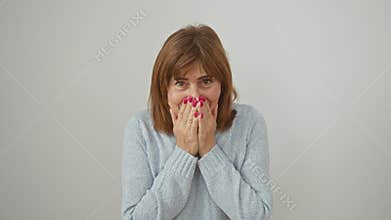 Embarrassed middle age woman caught in a scandal, laughing off her shame. standing, covering mouth with hand; sporting sweater,