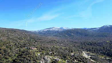 Aerial view of Yosemite National Park, green forests, rolling hills, snow-capped mountains, clear blue sky, scenic landscape,