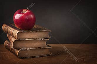 Stack of books and red apple