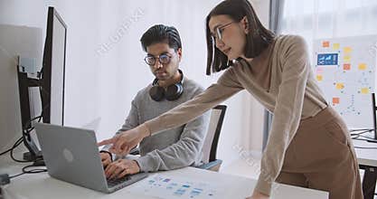Asian male, female software developer coding program on desktop computer. Man, woman work from home