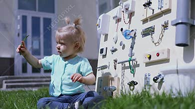 Little kid plays with grass near many home related
