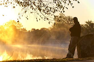 Adult Male Stands Alone At Sunrise Staring Towards