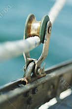 Closeup of old vintage metal yacht block with the rope, used to