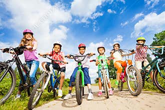Below angle view of kids in helmets with bikes