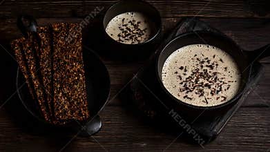 Warm Creamy Beverages with Seeded Crispbread on a Dark Rustic Wooden Background