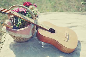 Guitar, basket with wine and bouquet of flowers