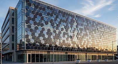 Modern office building with unique hexagonal facade and blue sky
