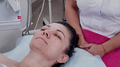 A woman lies on a couch in a cosmetologist's office before a procedure