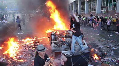 Man giving the finger with fire and tear gas bombs