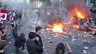 Man running over burning debris at riot - HD 1080p