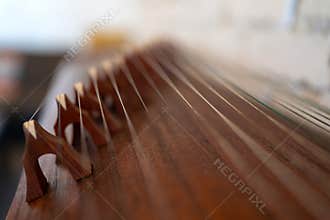 Close-Up of Traditional Chinese Guzheng Zither Strings and Wooden Bridges
