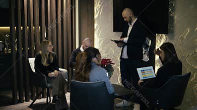 Diverse Business Team Collaborating and Discussing Strategies in a Modern Office Lounge Setting