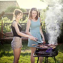 Two pretty girls making food on grill