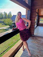 a woman stands on the balcony of her country house with a glass of red wine