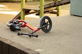 Abandoned Red Balance Bike on Playground