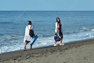 Teenage girl looks back while walking with mother