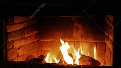 Cozy Burning Fire Inside a Brick Fireplace During the Night