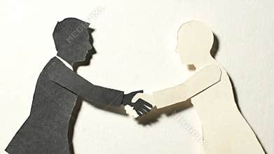 Black and White Paper Cutout Figures Shake Hands in a Studio Setting