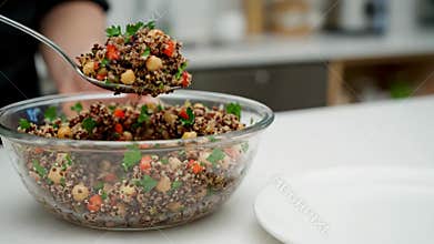 Making Quinoa Salad With Chickpeas and Vegetables in a Kitchen