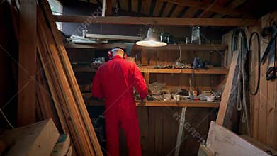 The master approaches the shelves in his workshop.