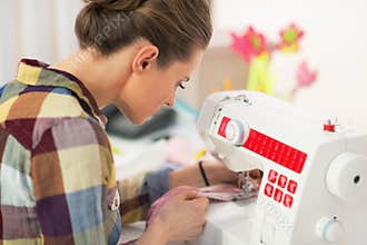 Seamstress working with sewing machine. rear view