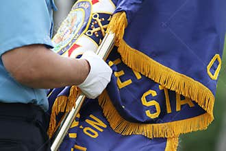 Detail of hand holding an American Legion Flag
