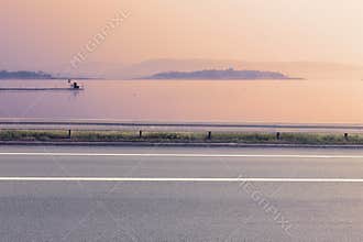 Side view of empty asphalt road and lake
