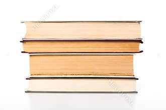 Stacked books display various shades and textures on a clean white background