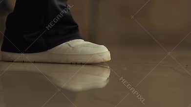 Close-up of Feet in White Shoes Walking on Polished Floor