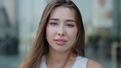 Portrait of attractive young woman smiles flirty standing on urban background