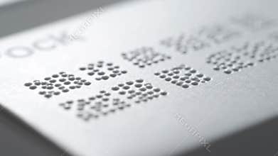 Close-up of Braille Dots and Text on White Card for Accessibility