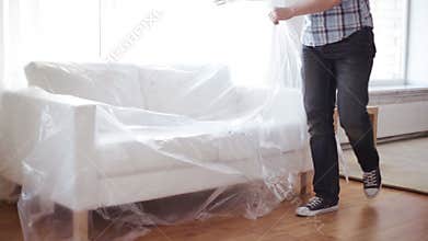 Male putting down new sofa at home
