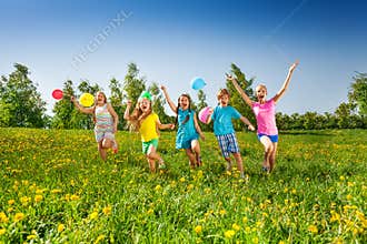 Happy five children with balloons run in field