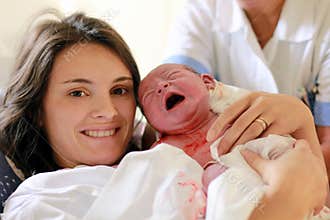 Happy mother holding her baby, seconds after she gave a birth, n