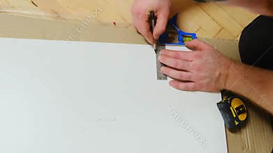 Construction worker draws marks on board to unsure accurate cut