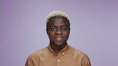 Portrait of Young African American Man Raising Head Looking at Camera Smiling