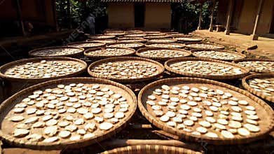 Cassava Root Slices Drying in Woven Baskets Under Sunlight Outside Rural Building Preparing Traditional Asian Food