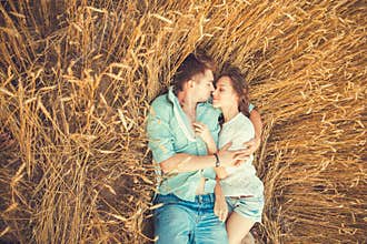 Young couple in love outdoor.Couple hugging.Young beautiful couple in love staying and kissing on the field on sunset.