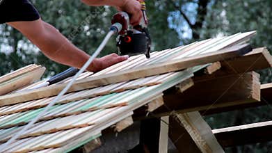 Using a machine to nail in the cedar wooden shingle roof tiles