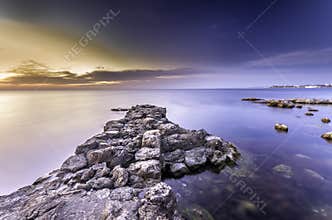 Amazing marvelous bright sunset and rocky seacost
