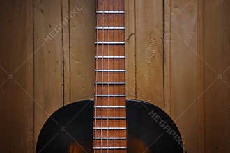 Details of an old jazz guitar on a wooden wall