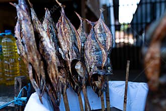 Smoked Fish on Wooden Skewers Displayed at a Local Outdoor Market Street Stall