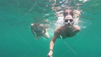 Young couple swimming together in open sea.