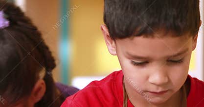 Preschool class painting at table in classroom