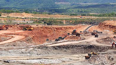 Zoom out mining dump trucks and excavators